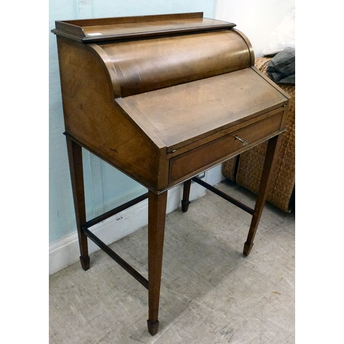 24 - An early 20thC string inlaid walnut finished roll top writing desk with a part-fitted interior, rais... 