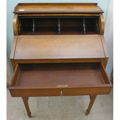 24 - An early 20thC string inlaid walnut finished roll top writing desk with a part-fitted interior, rais... 