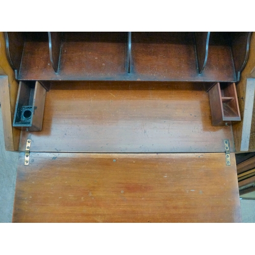 24 - An early 20thC string inlaid walnut finished roll top writing desk with a part-fitted interior, rais... 