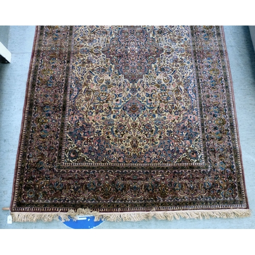 58 - A Persian part-silk rug, decorated with dense flora, on a maroon ground  80