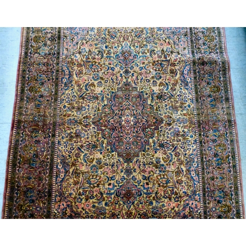 58 - A Persian part-silk rug, decorated with dense flora, on a maroon ground  80
