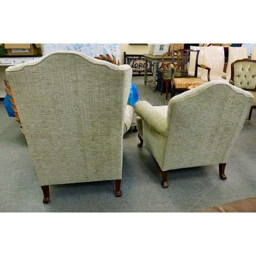 60 - Two similar modern wingback arm chairs, upholstered in beige fabric, raised on cabriole legs