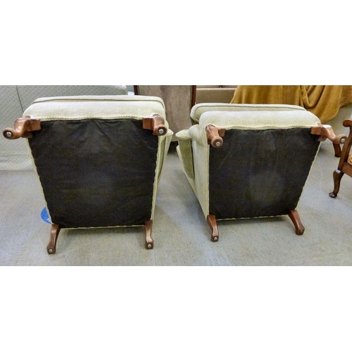 60 - Two similar modern wingback arm chairs, upholstered in beige fabric, raised on cabriole legs