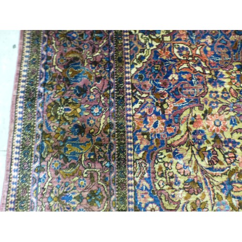 58 - A Persian part-silk rug, decorated with dense flora, on a maroon ground  80