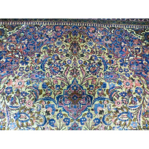 58 - A Persian part-silk rug, decorated with dense flora, on a maroon ground  80