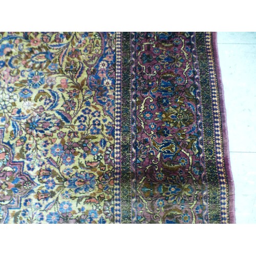 58 - A Persian part-silk rug, decorated with dense flora, on a maroon ground  80
