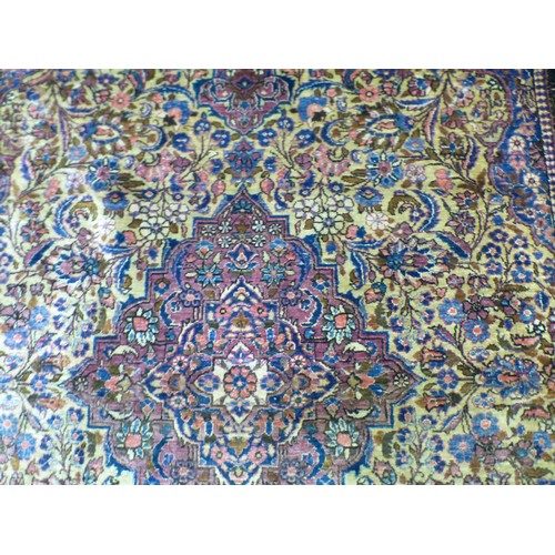 58 - A Persian part-silk rug, decorated with dense flora, on a maroon ground  80