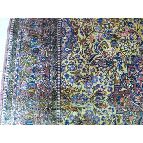 58 - A Persian part-silk rug, decorated with dense flora, on a maroon ground  80