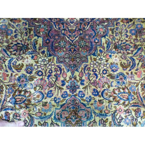 58 - A Persian part-silk rug, decorated with dense flora, on a maroon ground  80