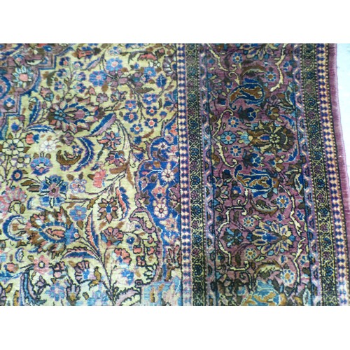 58 - A Persian part-silk rug, decorated with dense flora, on a maroon ground  80