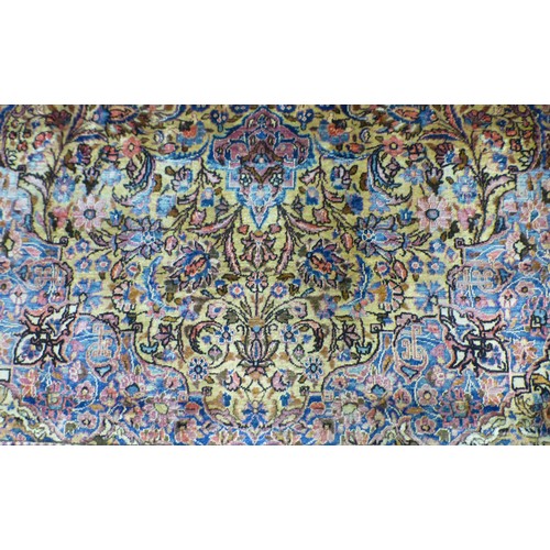 58 - A Persian part-silk rug, decorated with dense flora, on a maroon ground  80