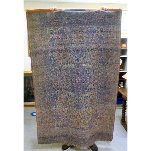 58 - A Persian part-silk rug, decorated with dense flora, on a maroon ground  80