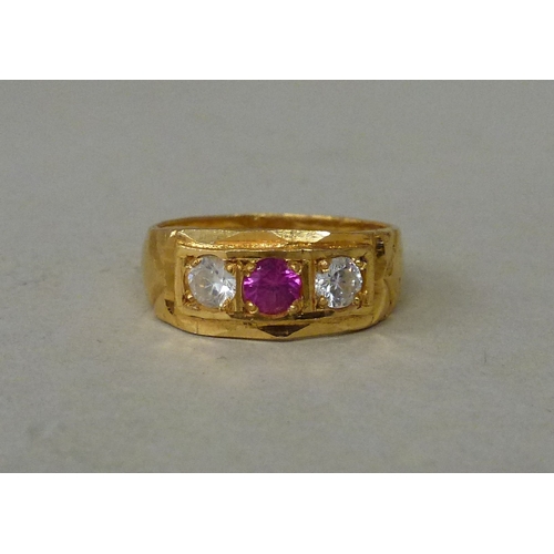 22 - A 22ct gold ring, set with a central ruby, flanked by two white stones  (approx. 5.2grms)