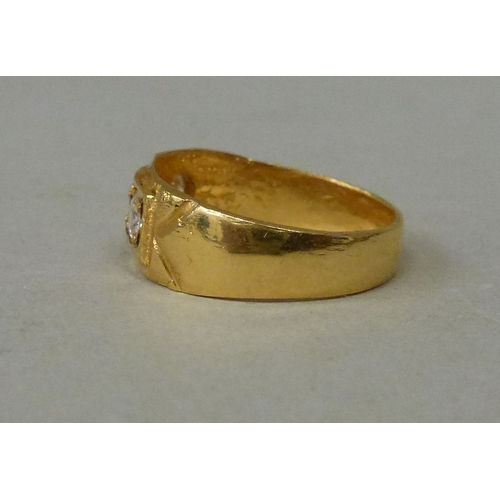 22 - A 22ct gold ring, set with a central ruby, flanked by two white stones  (approx. 5.2grms)