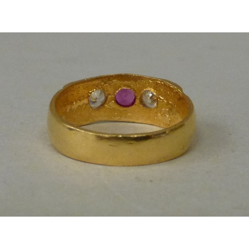 22 - A 22ct gold ring, set with a central ruby, flanked by two white stones  (approx. 5.2grms)