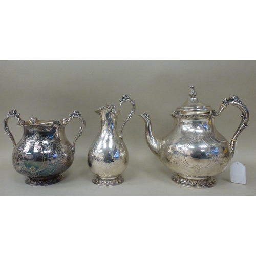 3 - A mid Victorian silver three piece tea set, comprising a teapot, sugar basin and milk jug with scrol... 