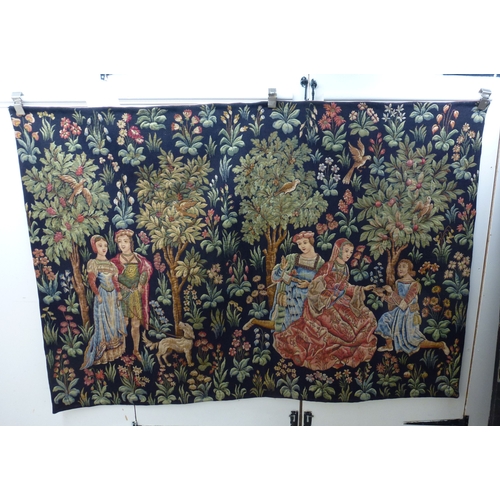 55 - HAL - a 20thC Flemish inspired tapestry hanging, depicting figures in period costume, in a woodland ... 
