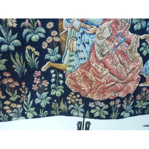55 - HAL - a 20thC Flemish inspired tapestry hanging, depicting figures in period costume, in a woodland ... 