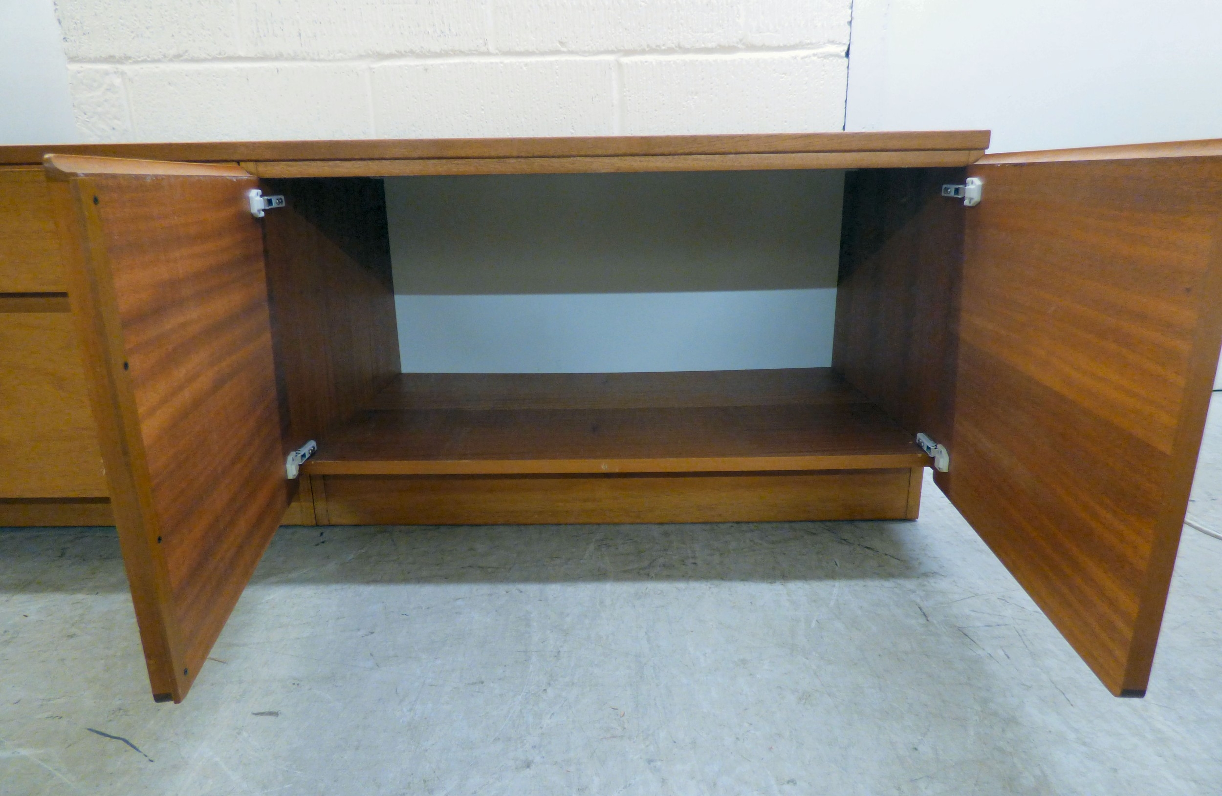 A modern teak low unit with a bank of two left hand drawers and two ...