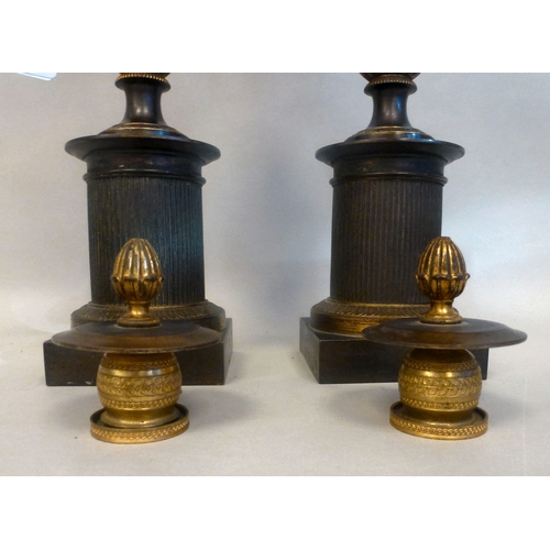 37 - A pair of late 19thC Empire design cast metal, urn design vases/candlesticks, on a plinth  14.5