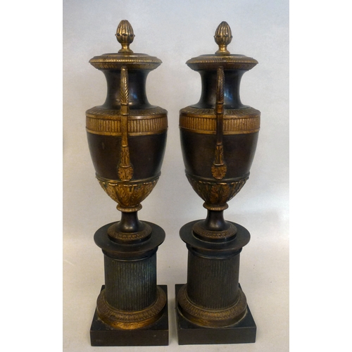 37 - A pair of late 19thC Empire design cast metal, urn design vases/candlesticks, on a plinth  14.5