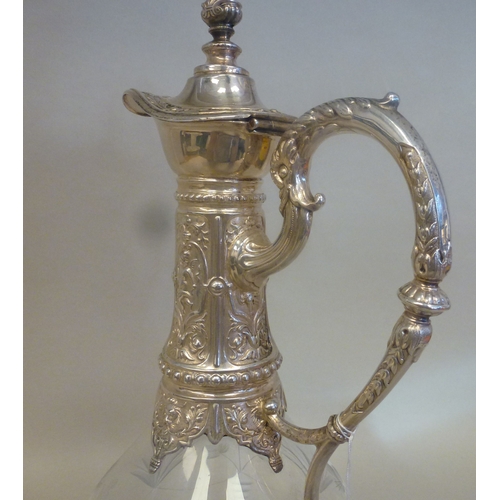 44 - A mid 20thC glass and silver plated claret jug, embossed with cherubs and swags&nbsp; 14