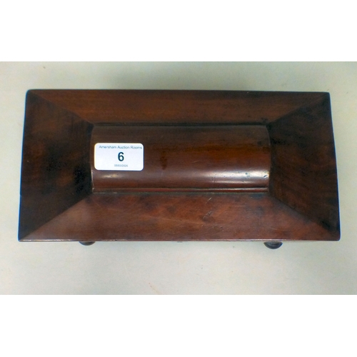 6 - A late Regency mahogany tea caddy of sarcophagus form, the hinged lid enclosing two lidded compartme... 