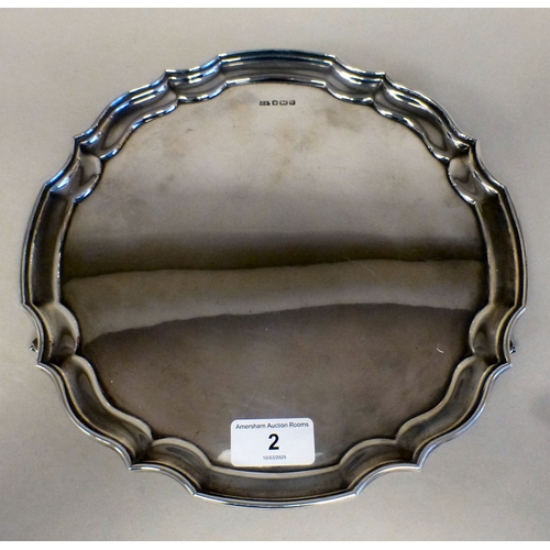 2 - A silver salver with a piecrust border, raised on scrolled feet&nbsp; Sheffield 1990&nbsp; 10