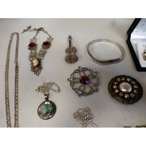 28 - Silver and white items of personal ornament: to include a 925 bangle; and a filigree floral design b... 
