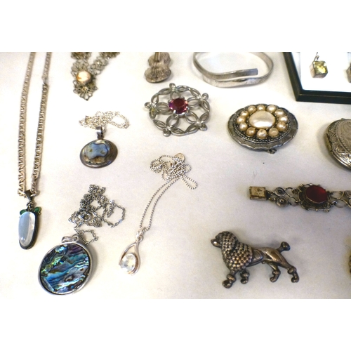28 - Silver and white items of personal ornament: to include a 925 bangle; and a filigree floral design b... 