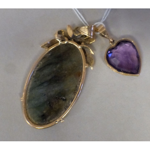 41 - A 14ct gold pendant, set with a carved green stone tablet; and a yellow metal heart shaped pendant, ... 