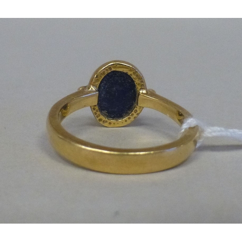 54 - A yellow metal ring, set with a blue stone&nbsp; stamped 750&nbsp; (approx. 4.6grms)
