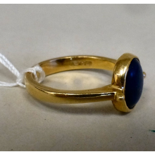 54 - A yellow metal ring, set with a blue stone&nbsp; stamped 750&nbsp; (approx. 4.6grms)