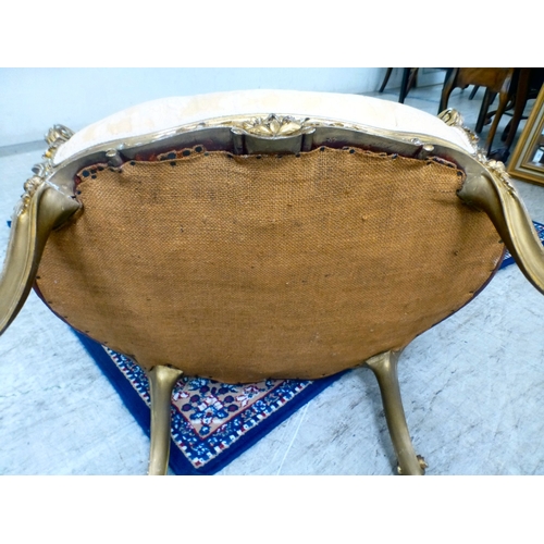 27 - A 20thC reproduction of an 18thC Continental gilt sprayed showwood salon chair, upholstered in flora... 