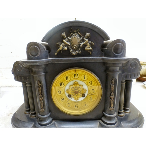 28 - An early 20thC black slate cased mantel clock of architectural form, on a plinth; the movement faced... 