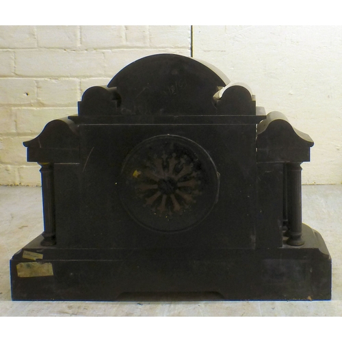 28 - An early 20thC black slate cased mantel clock of architectural form, on a plinth; the movement faced... 
