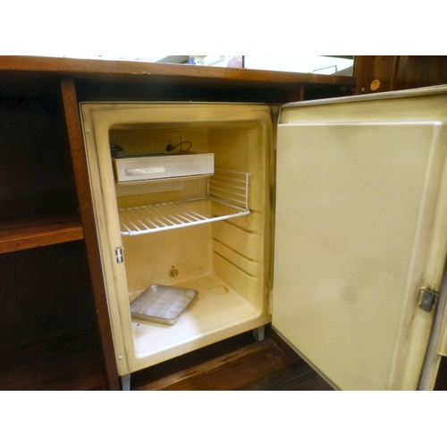 290 - An early/mid mahogany drinks cabinet with a pair of panelled doors, enclosing open shelves and a ref... 