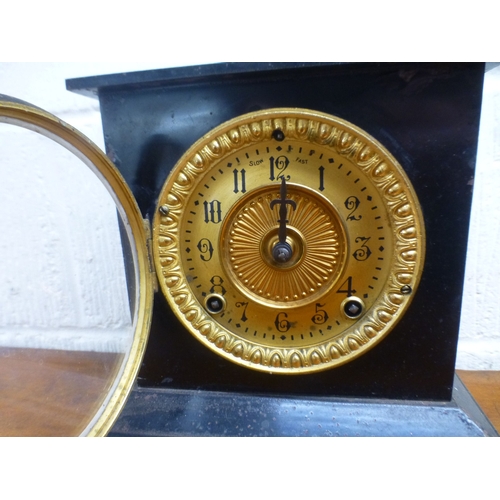 42 - An early 20thC black slate cased mantel clock, on a plinth; the movement faced by an Arabic dial  9.... 