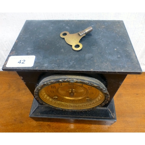 42 - An early 20thC black slate cased mantel clock, on a plinth; the movement faced by an Arabic dial  9.... 