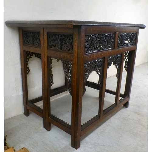 52 - An early 20thC Indian brass inlaid, carved fruitwood, folding occasional table, the drop-in top rais... 