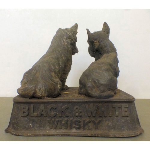 57 - A vintage cast metal advertising display for 'Buchanan's Black and White Whisky', depicting two Scot... 