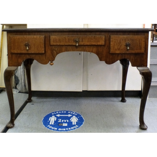198 - An early 20thC walnut veneered side table with three drawers, raised on cabriole legs and pad feet&n... 