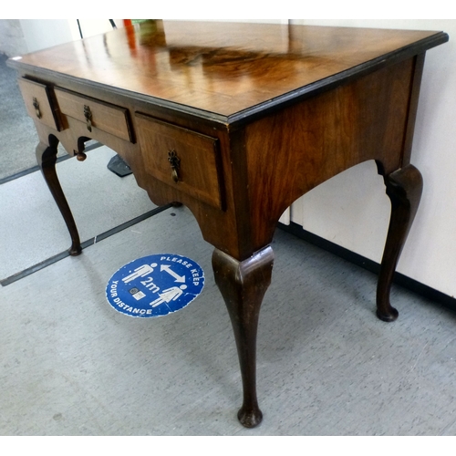 198 - An early 20thC walnut veneered side table with three drawers, raised on cabriole legs and pad feet&n... 