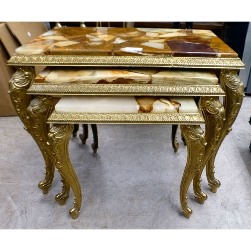 98 - A modern nesting set of three gilt metal framed tables with hardstone and resin surfaces, raised on ... 