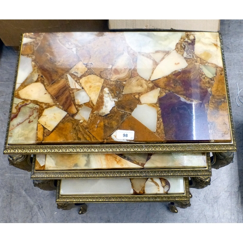 98 - A modern nesting set of three gilt metal framed tables with hardstone and resin surfaces, raised on ... 