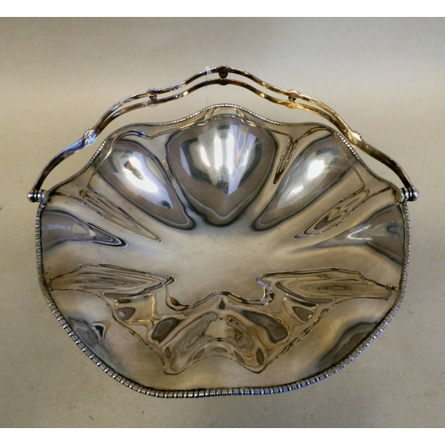 13 - A George V silver pedestal sweet basket with a swing handle and wavy edged border&nbsp; Sheffield 19... 