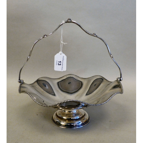 13 - A George V silver pedestal sweet basket with a swing handle and wavy edged border&nbsp; Sheffield 19... 