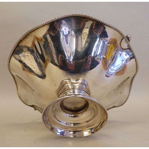 13 - A George V silver pedestal sweet basket with a swing handle and wavy edged border&nbsp; Sheffield 19... 