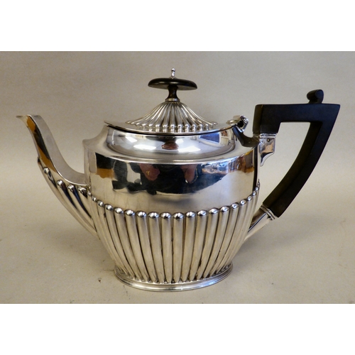 15 - An Elizabeth II silver teapot of Victorian influence demi-reeded form and wooden handle&nbsp; Sheffi... 