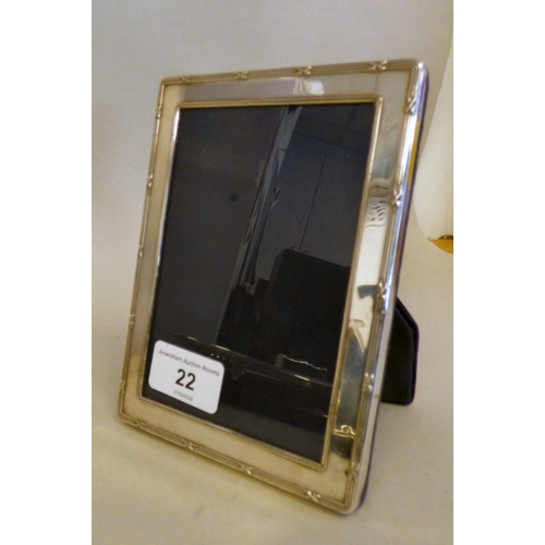 22 - A silver photograph frame of classical style, on a fabric easel back  3.5